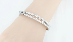 Detail of silver zipper bangle bracelet with sparkling rhinestones worn on wrist
