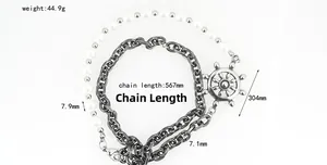 Detail of nautical rudder pendant with chunky silver cuban chain and white bead strands