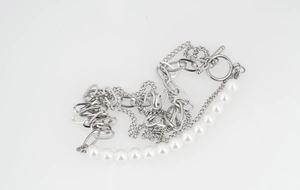 Detail view of multi-layer titanium steel necklace with white pearls and T-toggle clasp