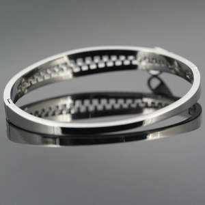 Polished silver titanium steel zipper bangle with geometric cutout pattern for women