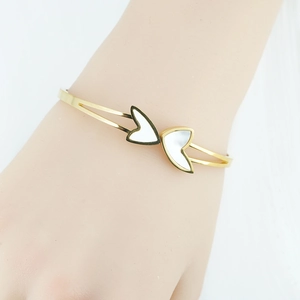 Elegant gold-plated stainless steel open bangle featuring white shell heart-shaped inlays