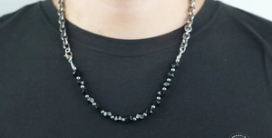 Dettaglio della collana a catena cubana in acciaio al titanio con perle di ossidiana nera