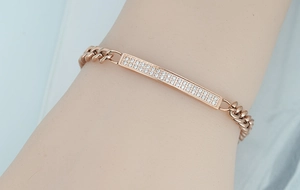Detail of rose gold Cuban link bracelet with micro-pave crystals on metal plate