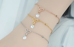 Ensemble de trois bracelets en acier titane rose, doré et argenté avec nœuds papillon