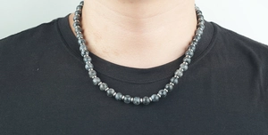 Détail d'un collier de perles en obsidienne gris foncé avec perles intercalaires argent