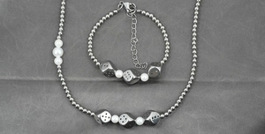 Detail of silver beads and white pearls necklace with punk style metal dice pendants