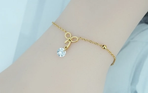 Vue macro d'un bracelet nœud doré avec un pendentif en zircon sur le poignet d'une femme