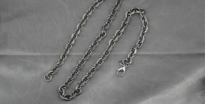 Close-up of vintage titanium steel Cuban chain with antique black finish and lobster clasp