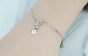 Détail du bracelet noeud argenté avec un pendentif en zircon rond sur une chaîne fine