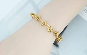 Detailed view of a gold-plated titanium steel double-layer chain with knot design on wrist