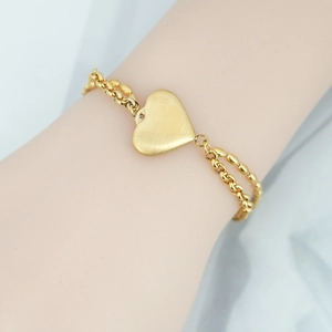 Bracciale dorato a doppio strato con ciondolo a cuore opaco su catene sovrapposte