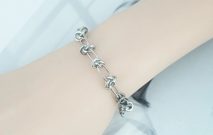 Close-up of silver titanium steel bracelet with double layer knotted links on wrist