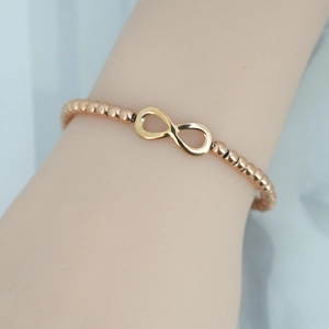 Elegant rose gold infinity beaded bracelet for women with polished metal finish and charm