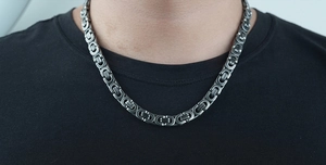 Close-up of industrial gunmetal titanium steel Cuban chain necklace on a black shirt