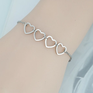 Minimalist silver stainless steel heart bracelet featuring four hollow heart links on wrist