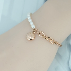 Bracelet élégant en acier titane doré avec perles blanches et pendentif visage souriant