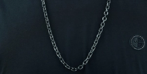 Detailed close-up of dark grey matte titanium steel Cuban link chain necklace