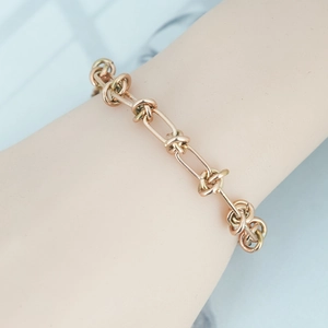 Elegant rose gold double-layered knotted chain bracelet worn on a woman's wrist