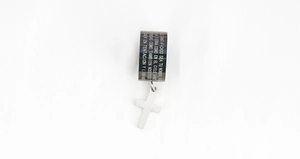 Macro shot of stainless steel cross pendant featuring Spanish Lord's Prayer engraving