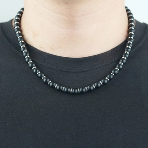 Collier minimaliste en perles noires pour homme avec entretoises argentées sur modèle