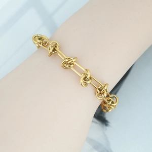 Elegant gold double-layered knotted chain bracelet for women on a female wrist