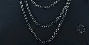 Macro detail of industrial style dark gray multi-layer steel cuban chain necklace
