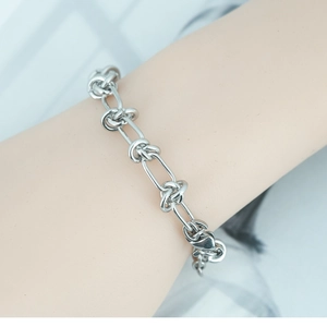 Polished silver stainless steel knot link bracelet for women worn on a wrist