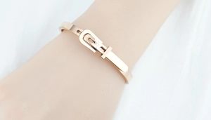 Détail d'un bracelet boucle en acier inoxydable rose doré poli porté au poignet