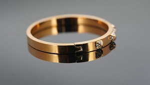 Close-up of rose gold stainless steel bangle featuring crystal encrusted triangle studs