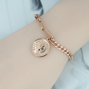Rose gold mixed chain bracelet with vintage Elizabeth II coin pendant on blue fabric