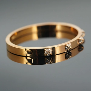 Elegant rose gold stainless steel hinged bangle with diamond pyramid studs and reflection