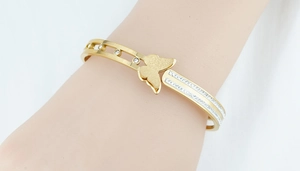 Detail of gold butterfly bracelet with matte finish and sparkling pavé crystals