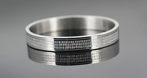 Macro detail of silver stainless steel bangle with Buddhist scripture engraving and reflection