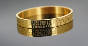 Makroaufnahme der Herz-Sutra-Gravur auf dem vergoldeten Titanstahl-Armband für Damen