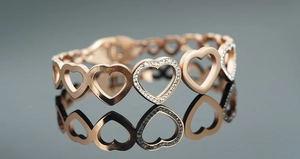 Vue macro du bracelet à maillons cœur en or rose avec cristaux scintillants