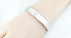 Detailed macro view of the silver titanium steel bracelet with engraved Buddhist scripture