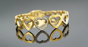 Gros plan du bracelet doré à cœurs ajourés avec incrustation de zircons brillants
