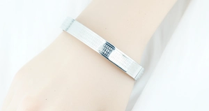 Macro detail of the polished silver stainless steel bracelet with engraved Buddhist scripture