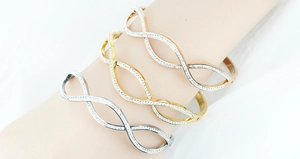 Detailed view of three-piece stackable wave bracelets in silver gold and rose gold