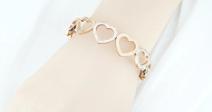 Gros plan d'un bracelet coeur en or rose avec zircons étincelants sur un mannequin