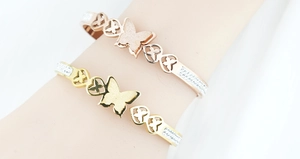 Dettaglio del bracciale a farfalla in oro rosa con cuori intagliati e finitura glitterata