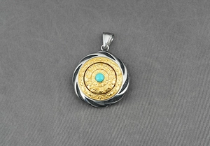 Detailed close-up of a rotating zodiac pendant with turquoise inlay and silver engravings