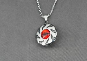 Macro view of vintage stainless steel spinning pendant with cat eye stone and flame texture