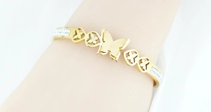 Dettaglio del bracciale a farfalla dorato con ritaglio a cuore opaco e micro-cristalli