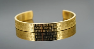 Macro detail of Buddhist Heart Sutra engraving on gold-plated stainless steel cuff bangle