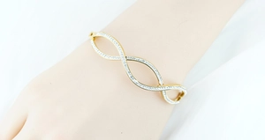 Detail of 18K gold-plated infinity bangle with pavé-set sparkling cubic zirconia stones