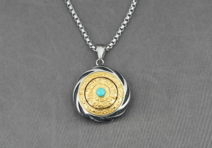Close-up of rotating zodiac pendant with turquoise stone and silver box chain detail