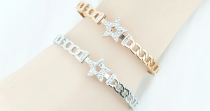 Detail of star-shaped bracelets with pavé crystals and Cuban chain links in gold and silver