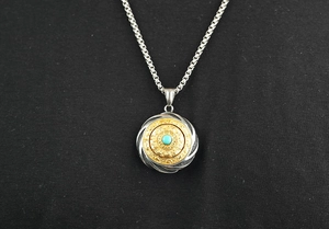 Detailed macro view of retro rotating pendant with turquoise stone and box chain