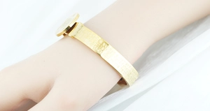 Detailed macro view of gold plated Buddhist Heart Sutra engraving on a stainless steel bangle